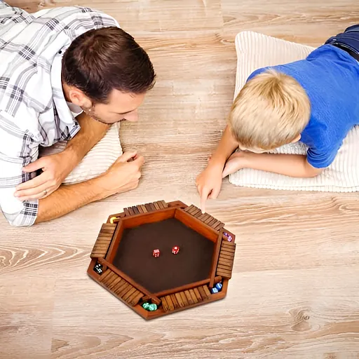 Two players at a low table playing a hexagonal wooden game board with red and blue pieces, focused interaction